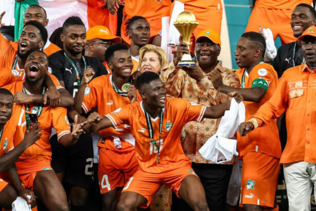 Le Président ivoirien Alassane Ouattara, soulevant le trophée de la CAN 2023